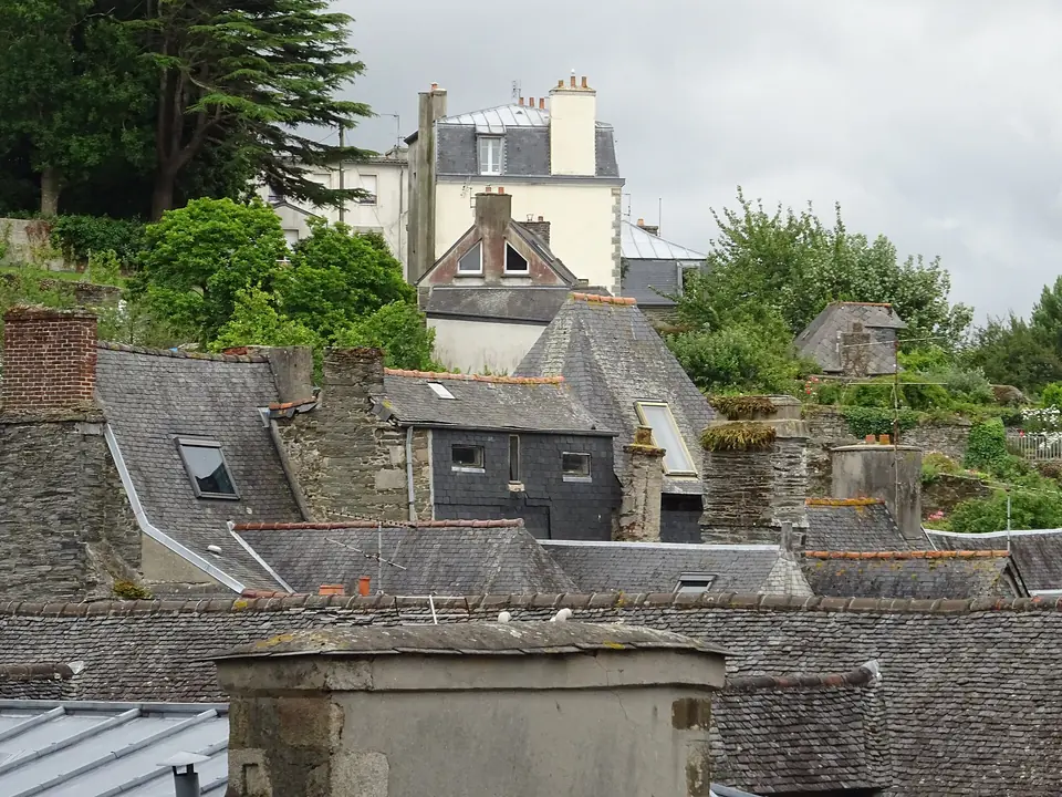 Succession de toits en ardoise, cheminées et lucarnes dans le centre de Morlaix.